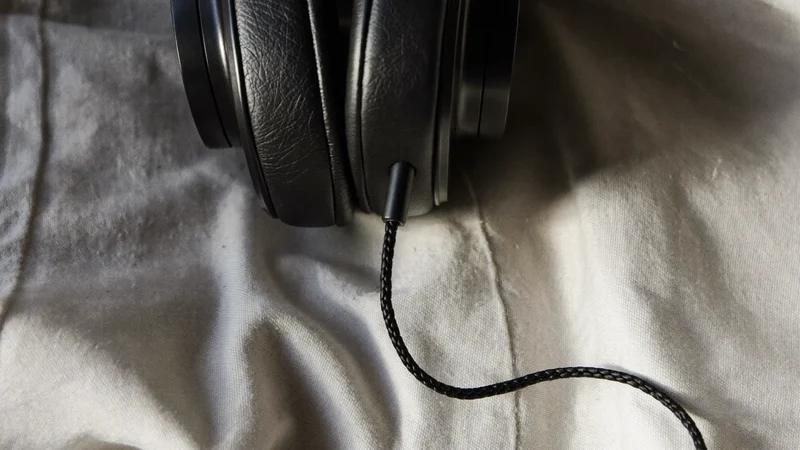 Nærbillede af hovedtelefonpude og flettet kabel på et stykke linned